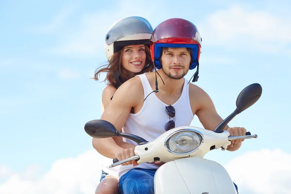 Paar in liefde plezier rijden op een scooter Stockafbeelding