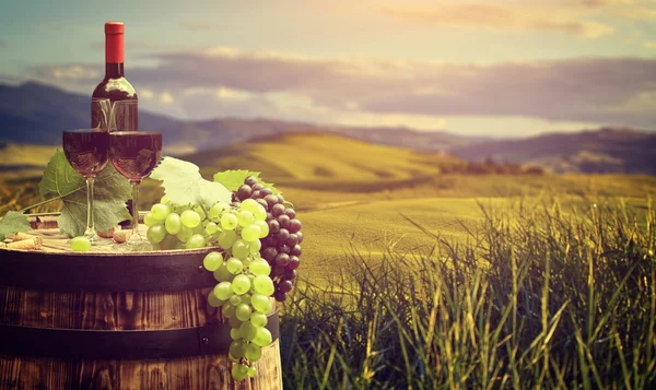 Şarap şişesi ve cam ahşap varil üzerinde — Stok fotoğraf