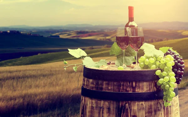 Wine bottle and glass on wooden barrel — Stock Photo, Image