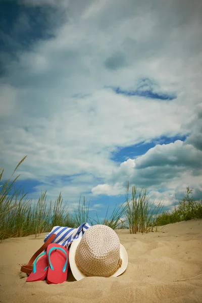 Chapéu e chinelos na praia — Fotografia de Stock