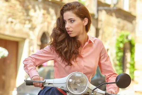Красивая женщина сидит на винтажном скутере — стоковое фото