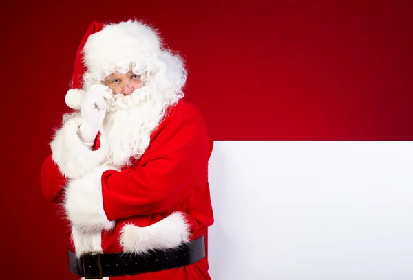 Weihnachtsmann zeigt auf weißen Rohling — Stockfoto