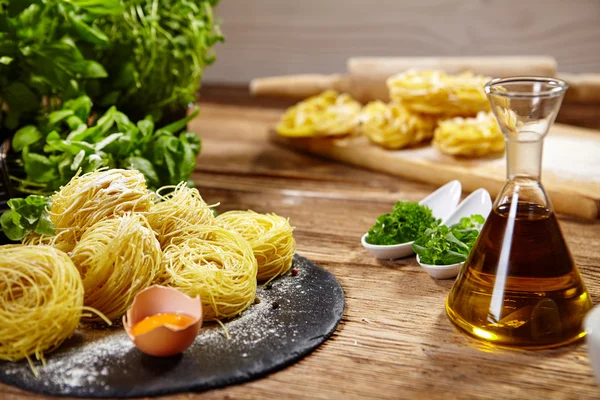 Pasta ingredients on table, with little olive oil bottle and rol — Stock Photo, Image