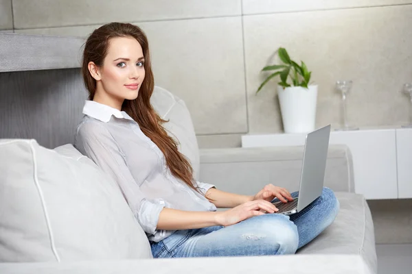 Kanepenin üzerinde dijital dizüstü bilgisayar kullanan kadın — Stok fotoğraf
