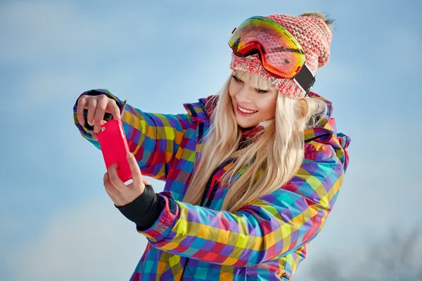 Flicka på snön och gör ett foto — Stockfoto