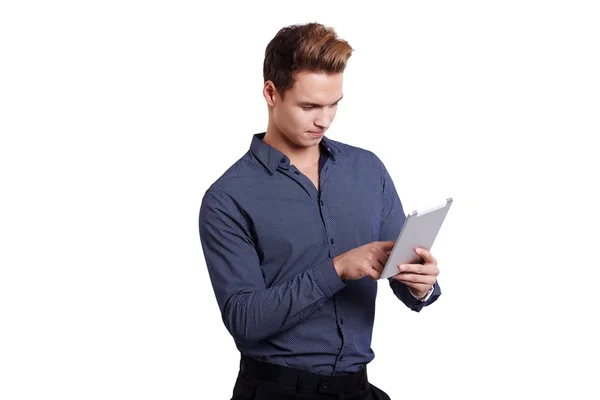 Smiling young man using tablet computer against a white background — Stock Photo, Image