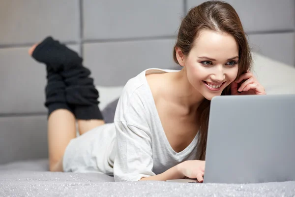 Szép nő, használ a laptop otthon hálószoba — Stock Fotó