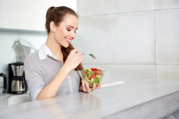 Casual brunett poserar när du äter sallad och innehar en blandad sa — Stockfoto