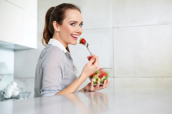 Brune décontractée posant tout en mangeant de la salade et tenant une sa mixte — Photo