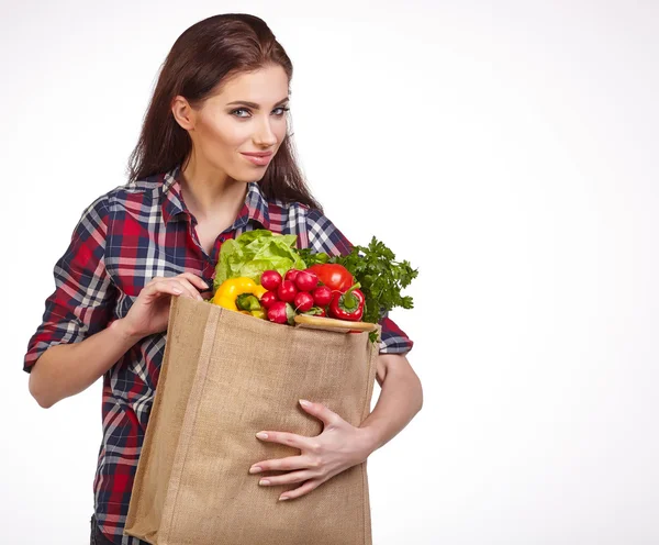 Kvinna med grönsaker i väska — Stockfoto