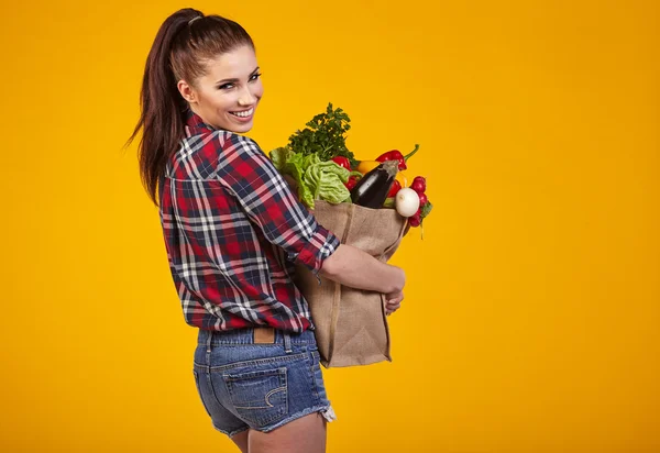 Ung kvinna med livsmedelsbutiker — Stockfoto