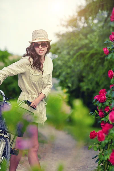 Frau mit Fahrrad im Garten — Stockfoto