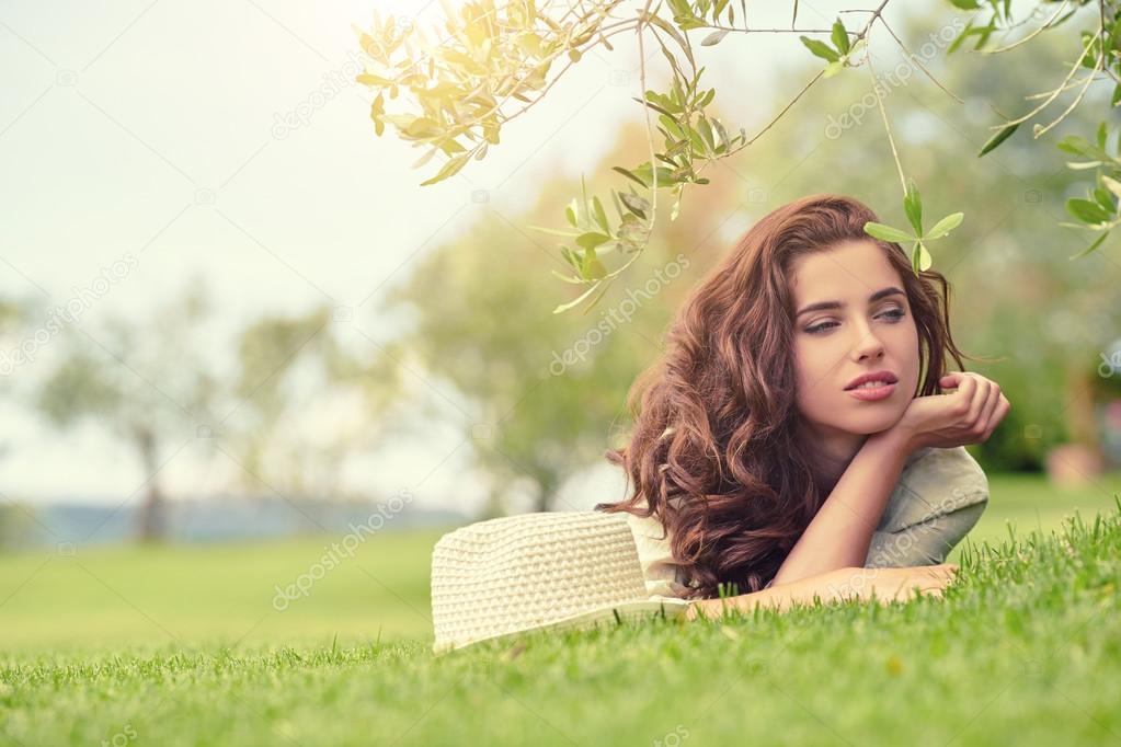 woman lying on grass outdoors