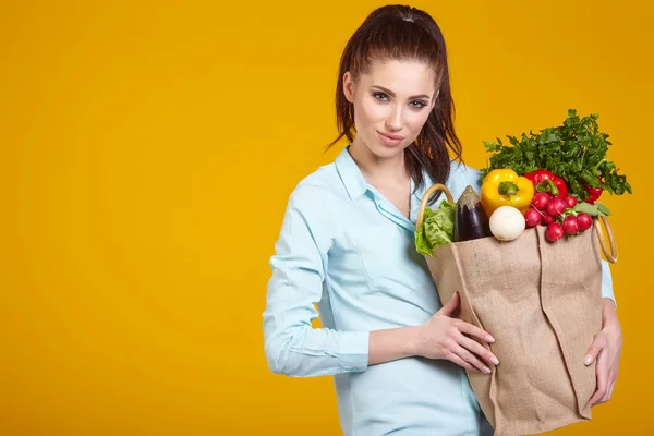 Kvinna med grönsaker i väska — Stockfoto