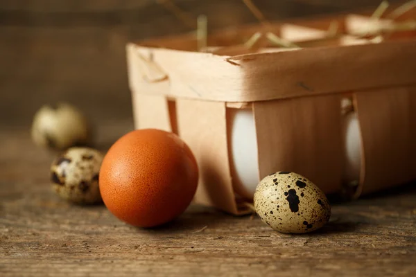 Huevos de pollo y codorniz sobre un fondo rústico de madera —  Fotos de Stock