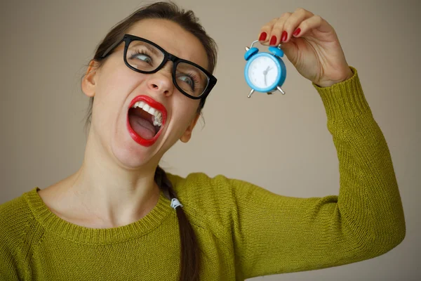 Kleiner blauer Wecker in den Händen einer emotionalen jungen Frau — Stockfoto