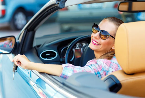 Mujer bonita joven en gafas de sol sentado en un coche convertible wi —  Fotos de Stock