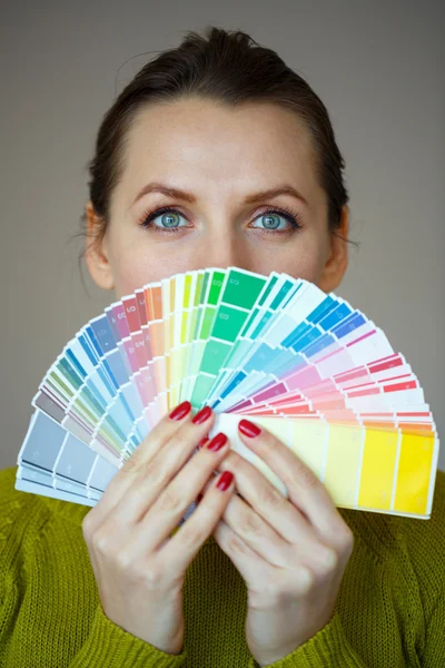 Mujer en gafas mirando a una paleta de pintura de color —  Fotos de Stock