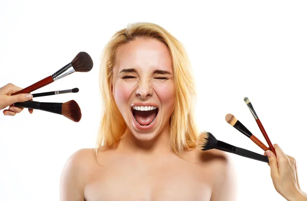 Lustige junge Frau mit Make-up-Pinseln in der Nähe ihres Gesichts — Stockfoto