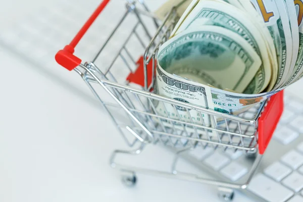 Dollars in the shopping cart on a computer keyboard — Stock Photo, Image