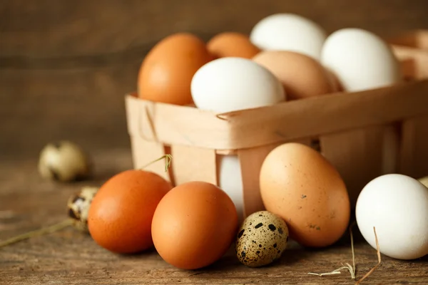 Kuře a křepelčí vejce na dřevěný rustikální pozadí — Stock fotografie