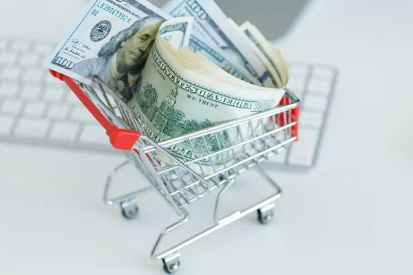 Dollars in the shopping cart on a computer keyboard — Stock Photo, Image