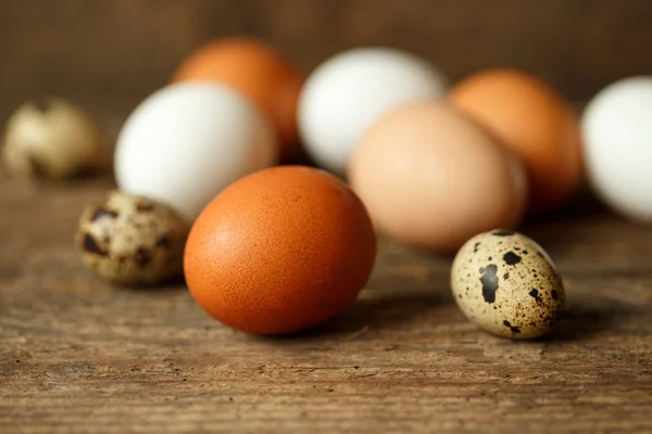 Huevos de pollo y codorniz sobre un fondo rústico de madera —  Fotos de Stock