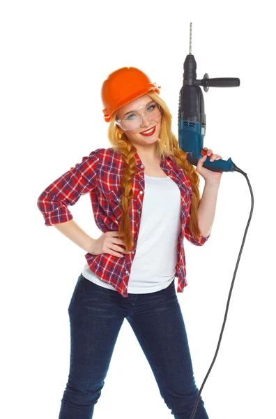 Trabalhadora da construção feminina em um chapéu duro com um perfurador — Fotografia de Stock