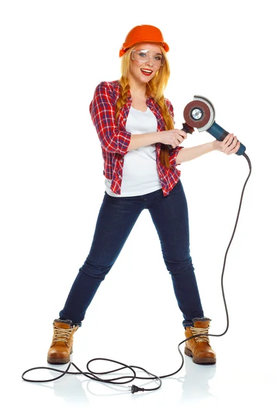 Female construction worker in a hard hat with angle grinder over — Stock Photo, Image