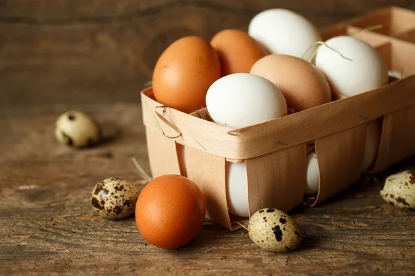 Pollo fresco e uova di quaglia su uno sfondo di legno — Foto Stock