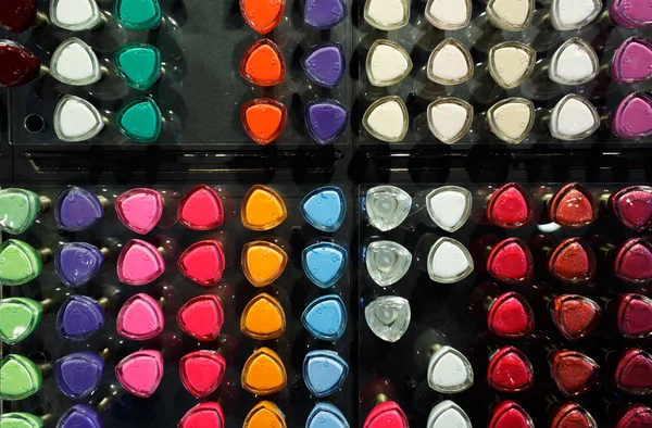 Set of different nail varnishes on shelves in cosmetic store — Stock Photo, Image