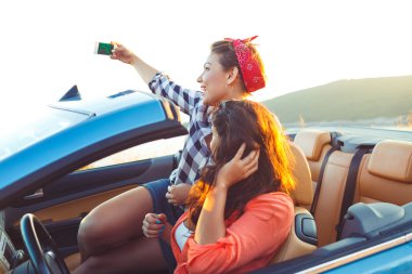 İki genç güzel kız selfie üstü açık bir araba içinde yapıyorsun