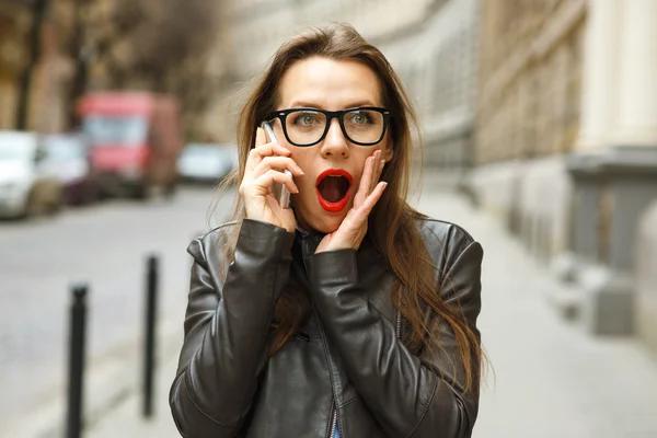 Surprised woman walking down the street while talking on smart p — Stock Photo, Image