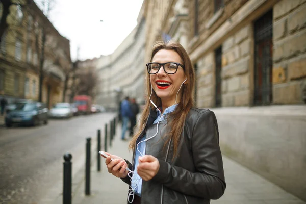 Mujer de negocios caminando por la calle mientras usa el teléfono inteligente —  Fotos de Stock