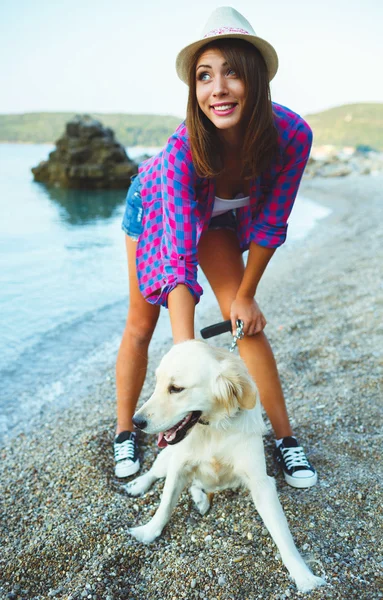 Mulher com um cão em um passeio na praia — Fotografia de Stock