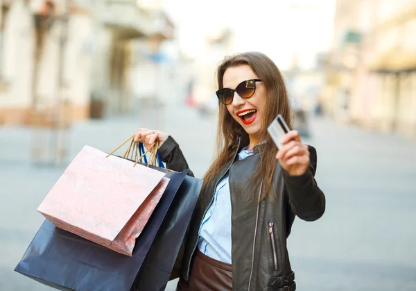 Felice bella donna con borse della spesa e carta di credito nel — Foto Stock