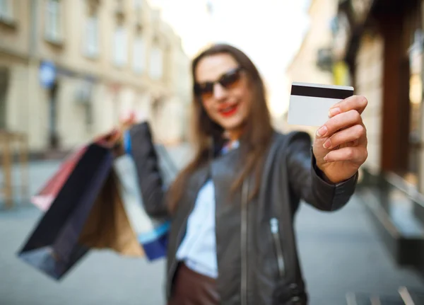 Happy beautiful woman with shopping bags and credit card in the — Stock Photo, Image