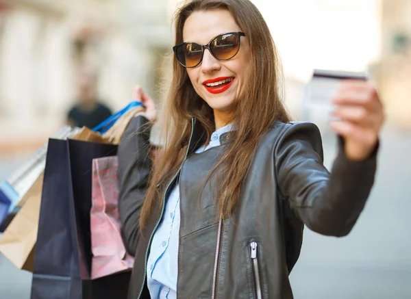 Feliz hermosa mujer con bolsas de compras y tarjeta de crédito en el —  Fotos de Stock