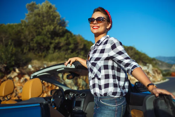 Beautiful pin up woman sitting in cabriolet, enjoying trip on lu