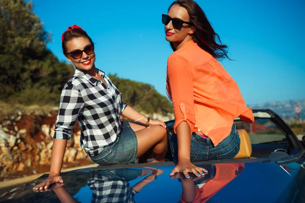 Two young happy girls having fun in the cabriolet outdoors — Stock Photo, Image