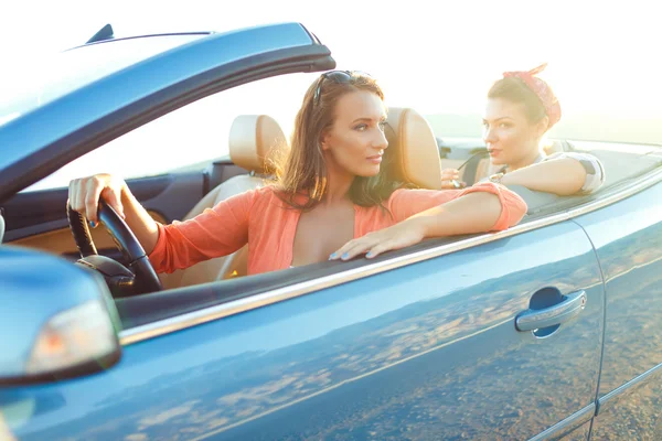 Dos chicas felices jóvenes conduciendo un cabriolet — Foto de Stock