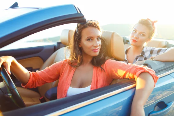 Две молодые счастливые девушки за рулем кабриолета — стоковое фото