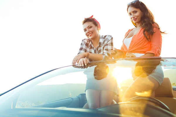 Dos chicas felices jóvenes divirtiéndose en el cabriolet al aire libre — Foto de Stock