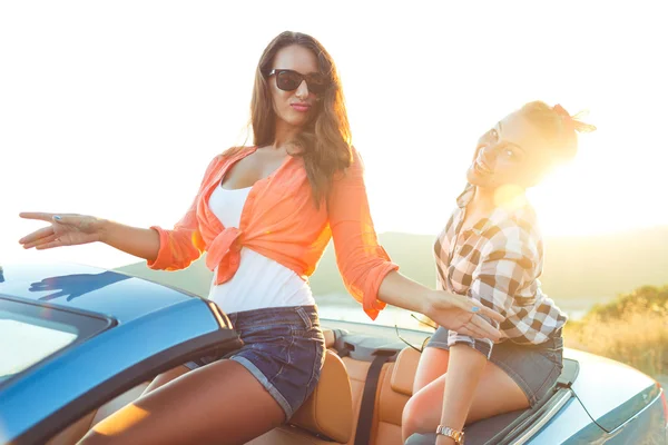 Dos chicas felices jóvenes divirtiéndose en el cabriolet al aire libre —  Fotos de Stock