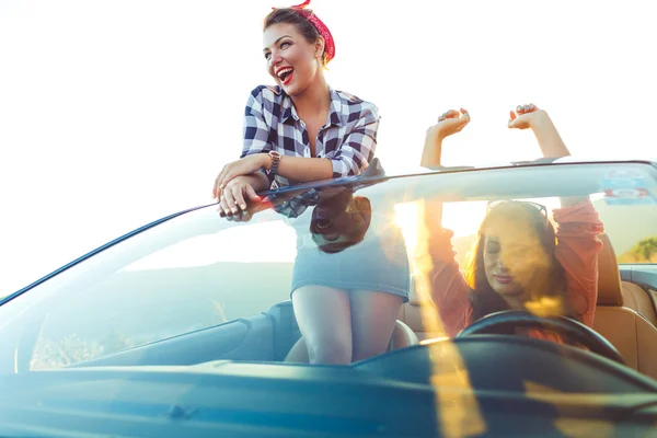 Två unga glada tjejer ha roligt i cabriolet utomhus — Stockfoto