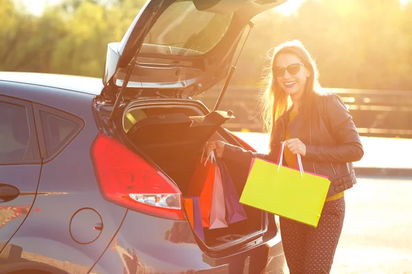 Donna caucasica mettendo le borse della spesa nel bagagliaio della macchina — Foto Stock