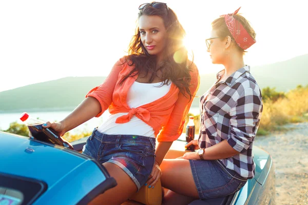 Две молодые счастливые девушки веселятся в кабриолете на открытом воздухе — стоковое фото