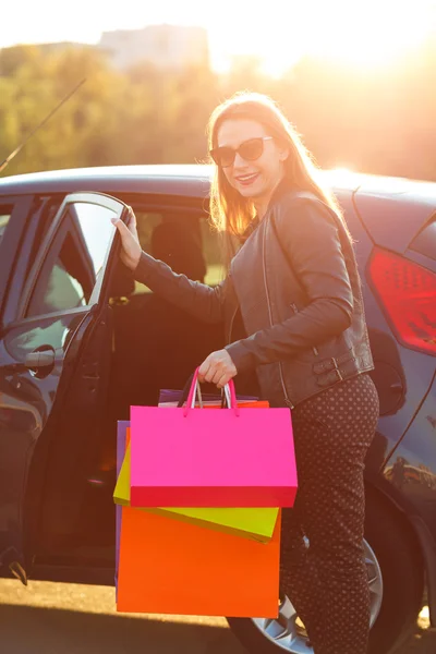 Lächelnde Kaukasierin steckt ihre Einkaufstüten ins Auto — Stockfoto