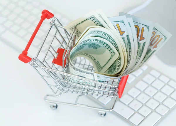 Dollars in the shopping cart on a computer keyboard — Stock Photo, Image