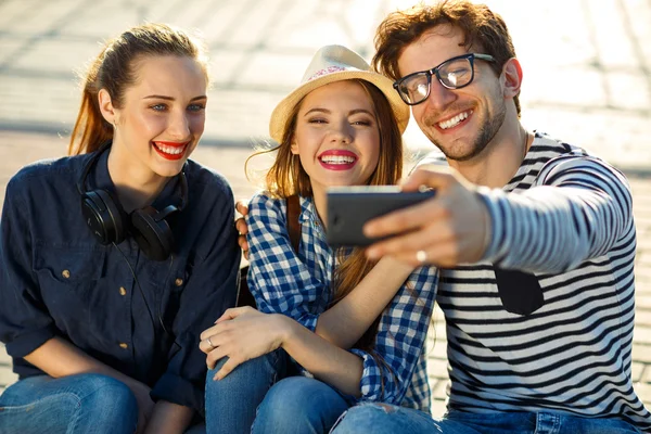 Glimlachend vrienden maken selfie buitenshuis — Stockfoto